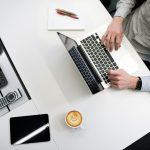 professionally dressed man using a laptop at an office desk
